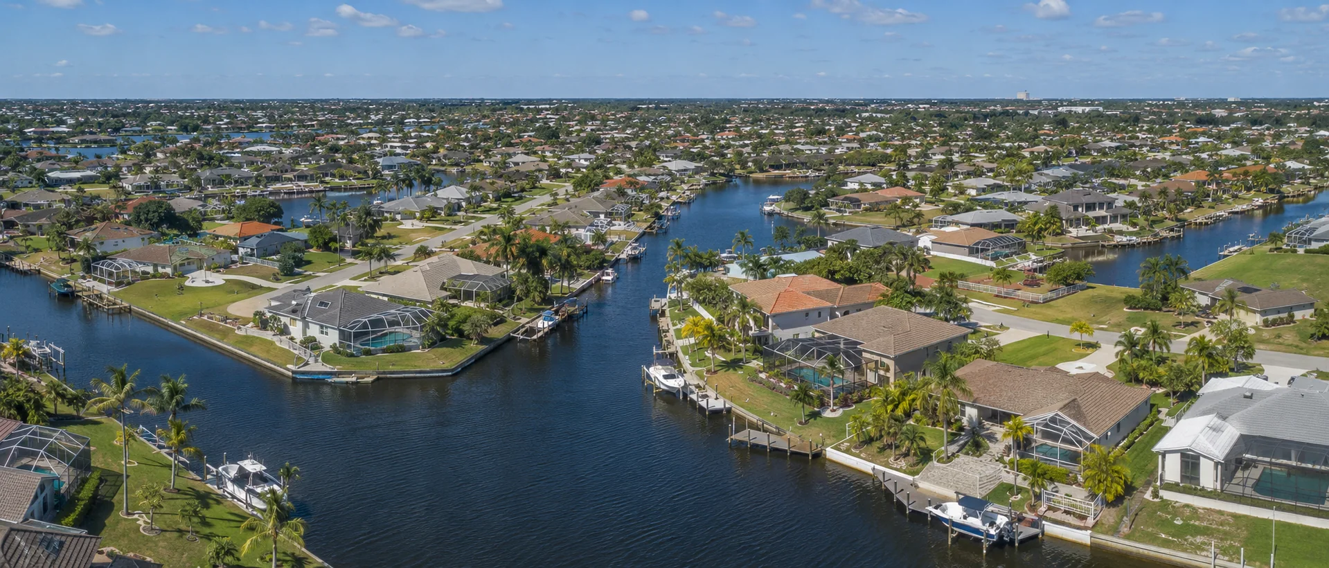Cape Coral canal neighborhoods with homes, docks, pools and intersecting waterways.