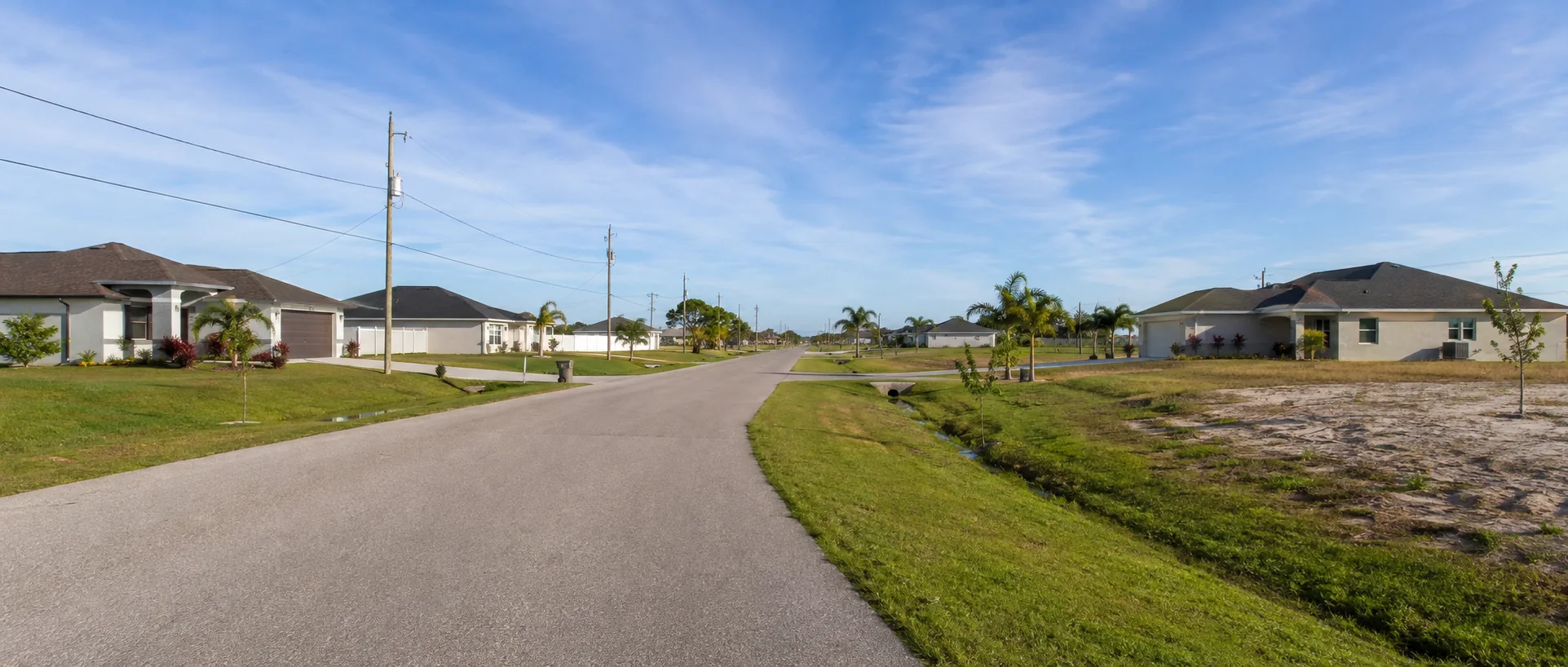 Waterfront homes, screened pools and boat docks along a canal representing Cape Coral’s Pelican area.