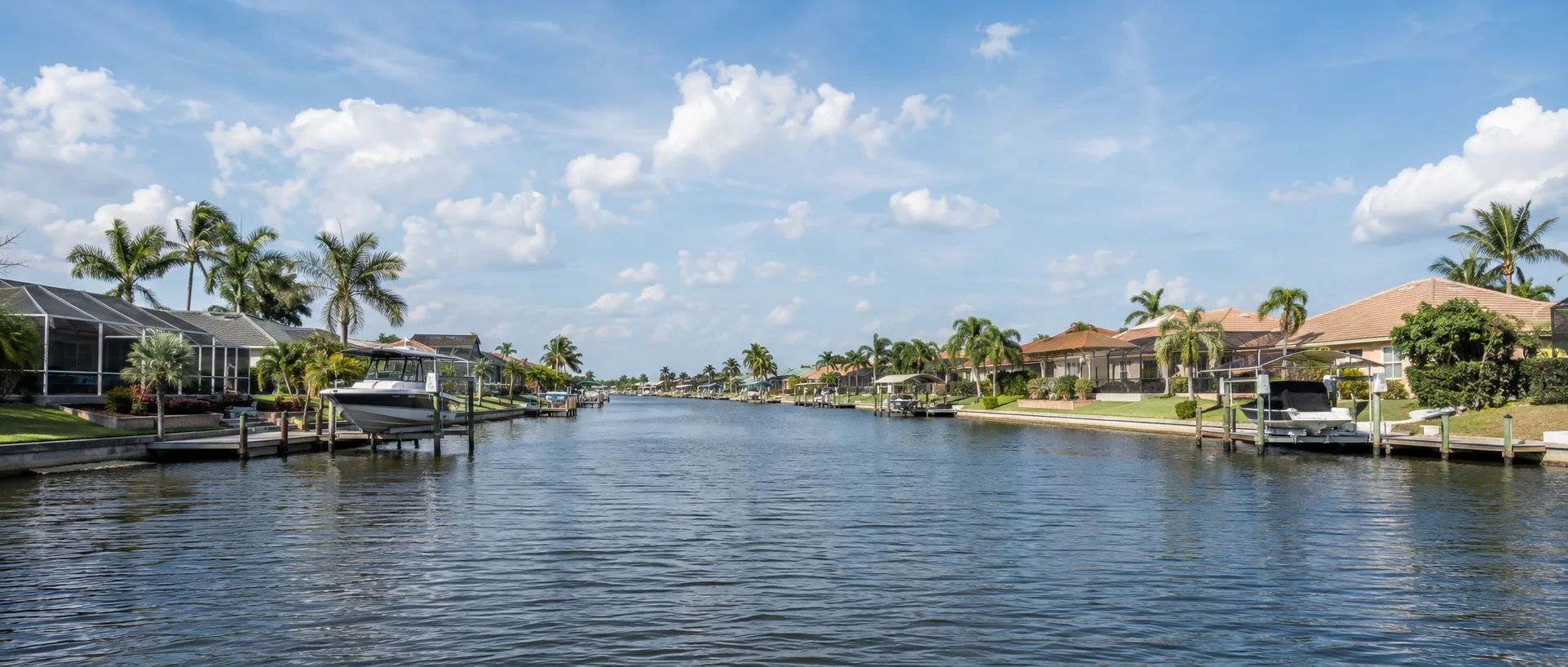 Established canal homes and mature palms representing Cape Coral’s Yacht Club Area.