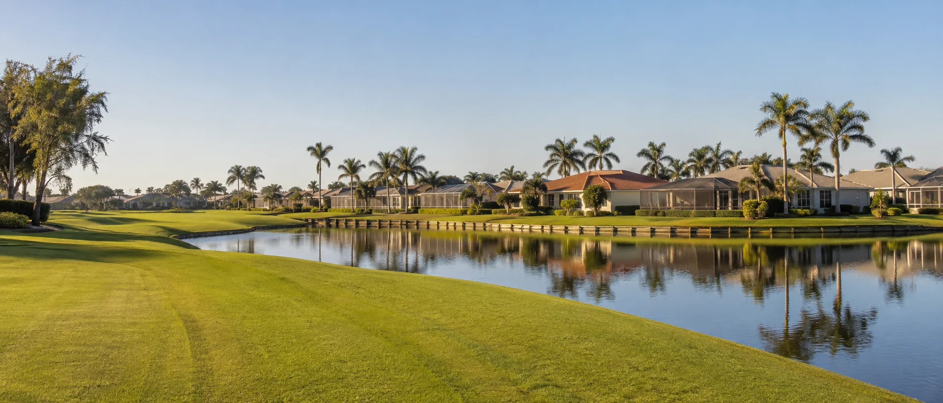 Homes beside a fairway and lake representing a central Cape Coral golf community.