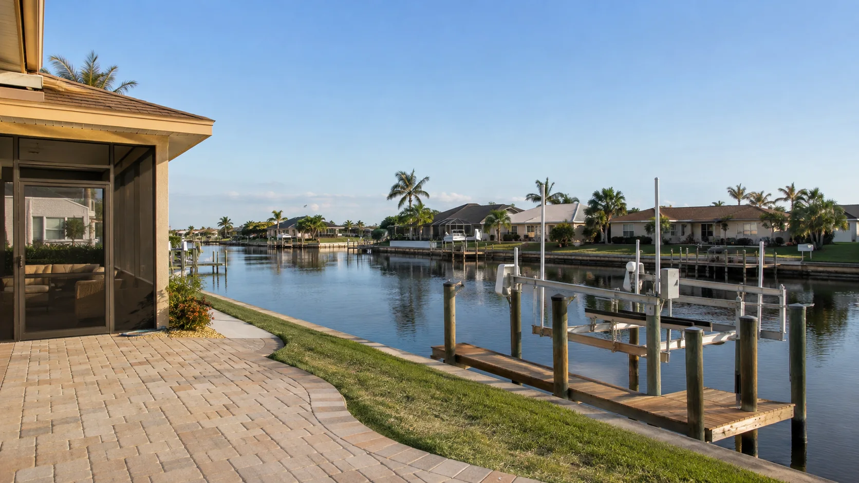 Residential Cape Coral canal with waterfront homes, docks and a boat lift.