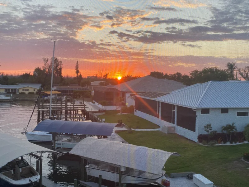 Sunset over a Cape Coral canal, viewed from a lanai