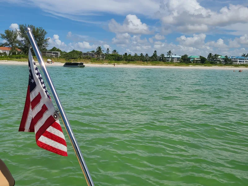 Boat cruising with an American flag flying, Southwest Florida