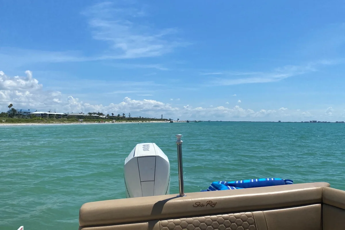 Sanibel coastline with turquoise water, white beach, and homes in the distance