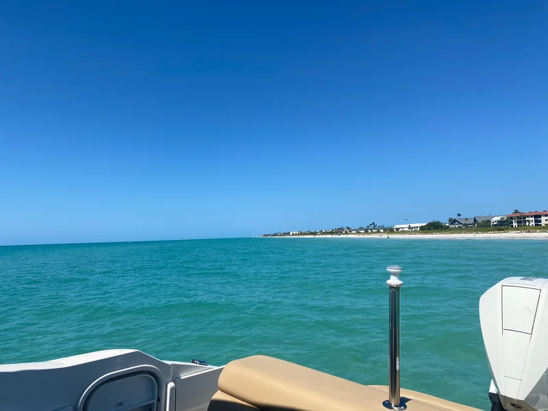 Sanibel shoreline viewed from a boat across turquoise Gulf water