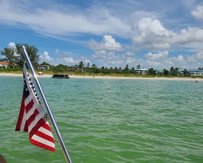 American flag on a boat approaching a Southwest Florida beach