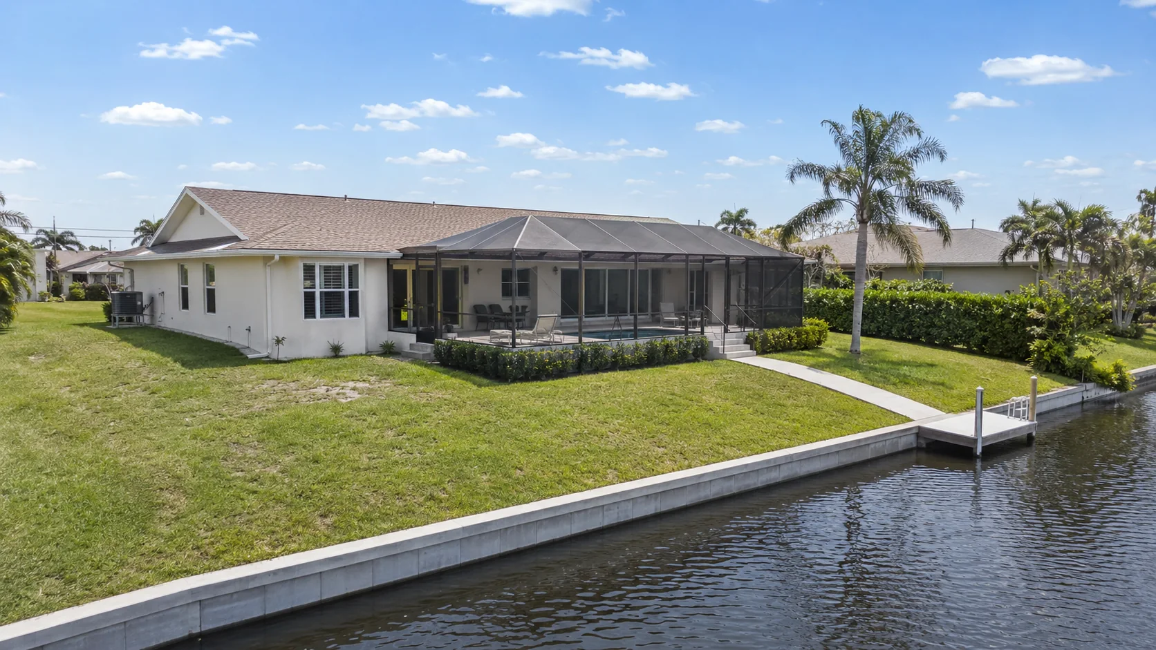 Cape Coral waterfront home showing the relationship between finished-floor height, yard grade, seawall and canal.